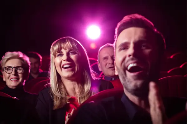 a laughing audience having a night out on the house as seat fillers