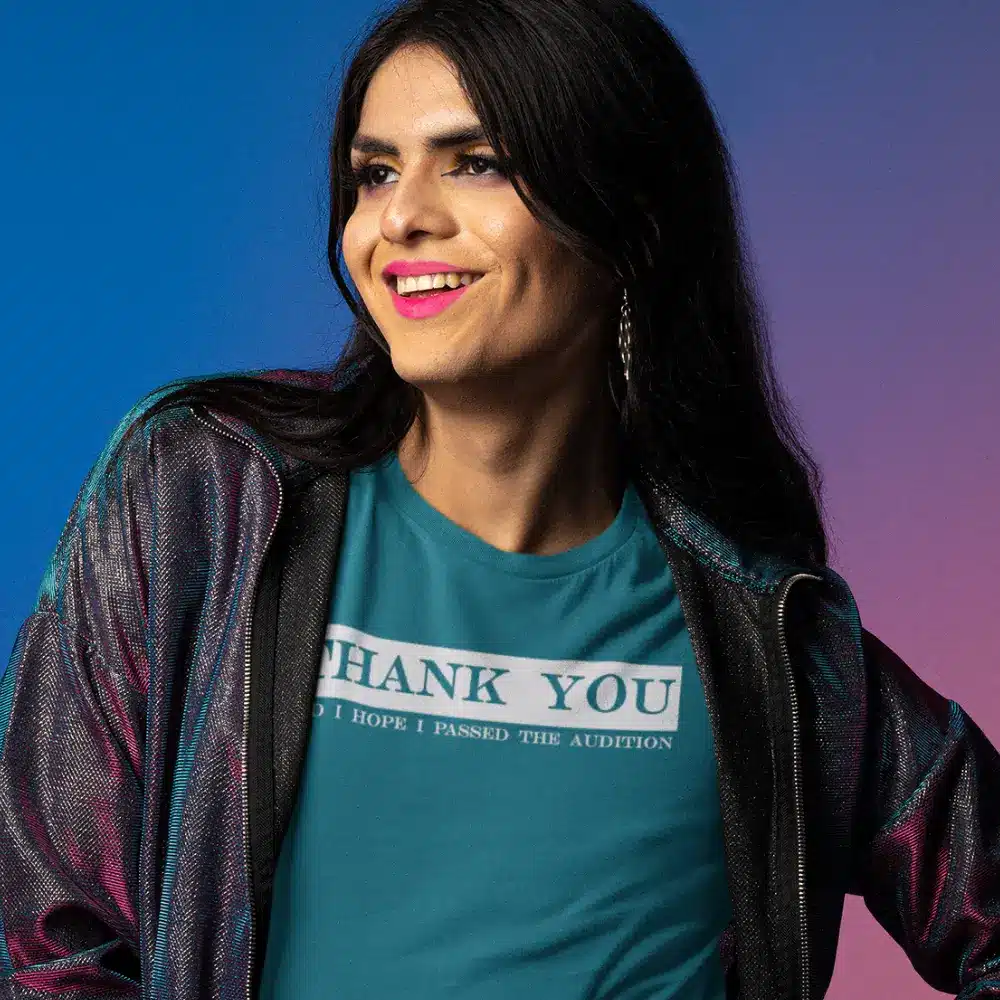 Person wearing a teal t-shirt with the phrase THANK YOU I HOPE I PASSED THE AUDITION" printed on it.