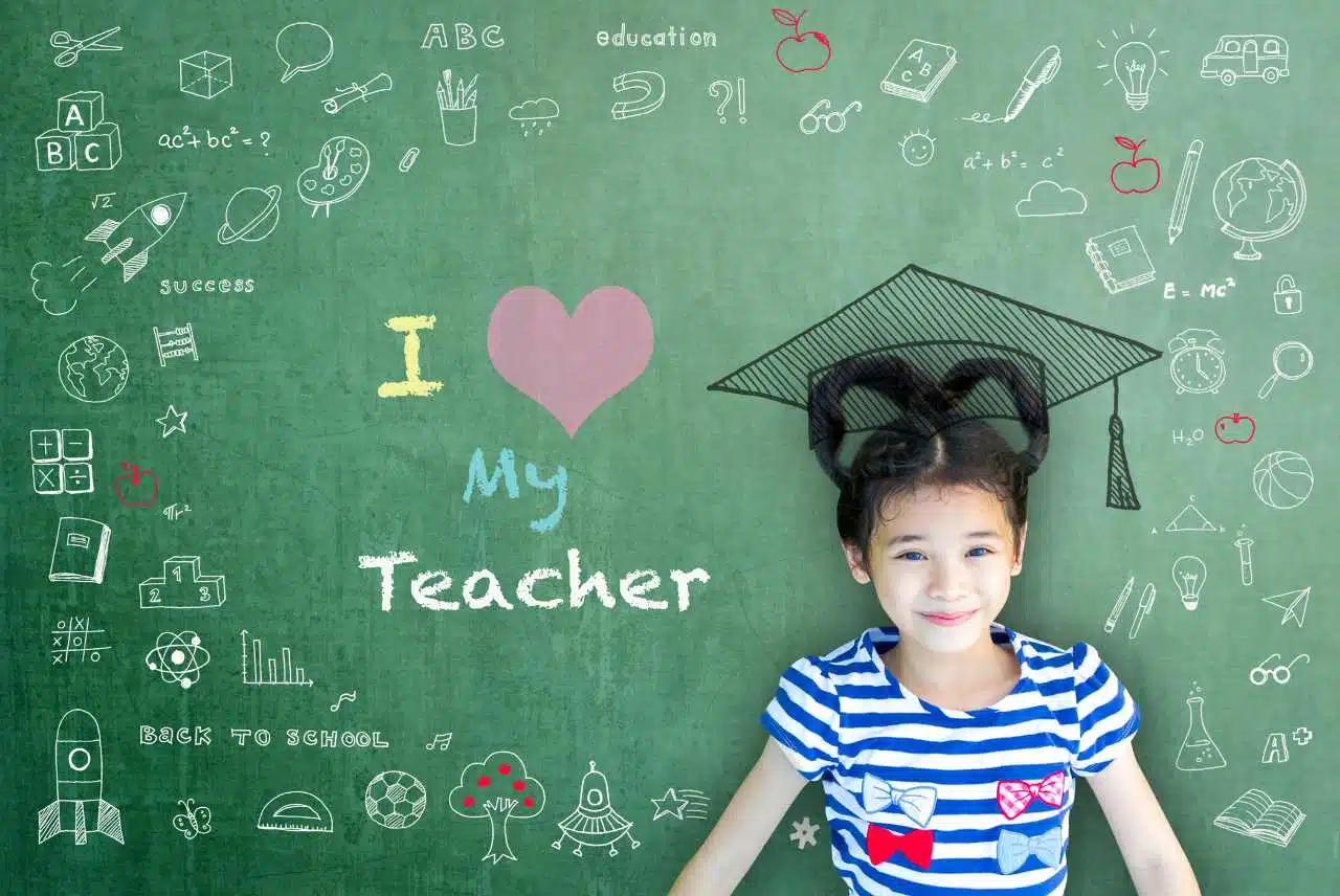 a student leaning against a chalkboard with the words I love my teacher
