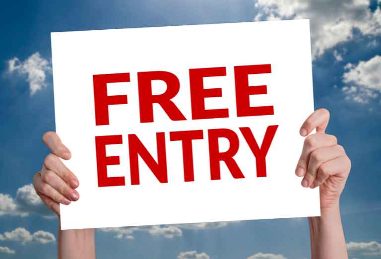 Two hands holding a sign reading free entry depicting free admission for seat fillers