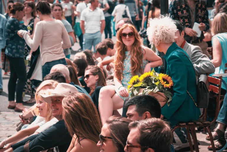 Crowds enjoying a sunny outdoor festival in London with live entertainment and summer activities.