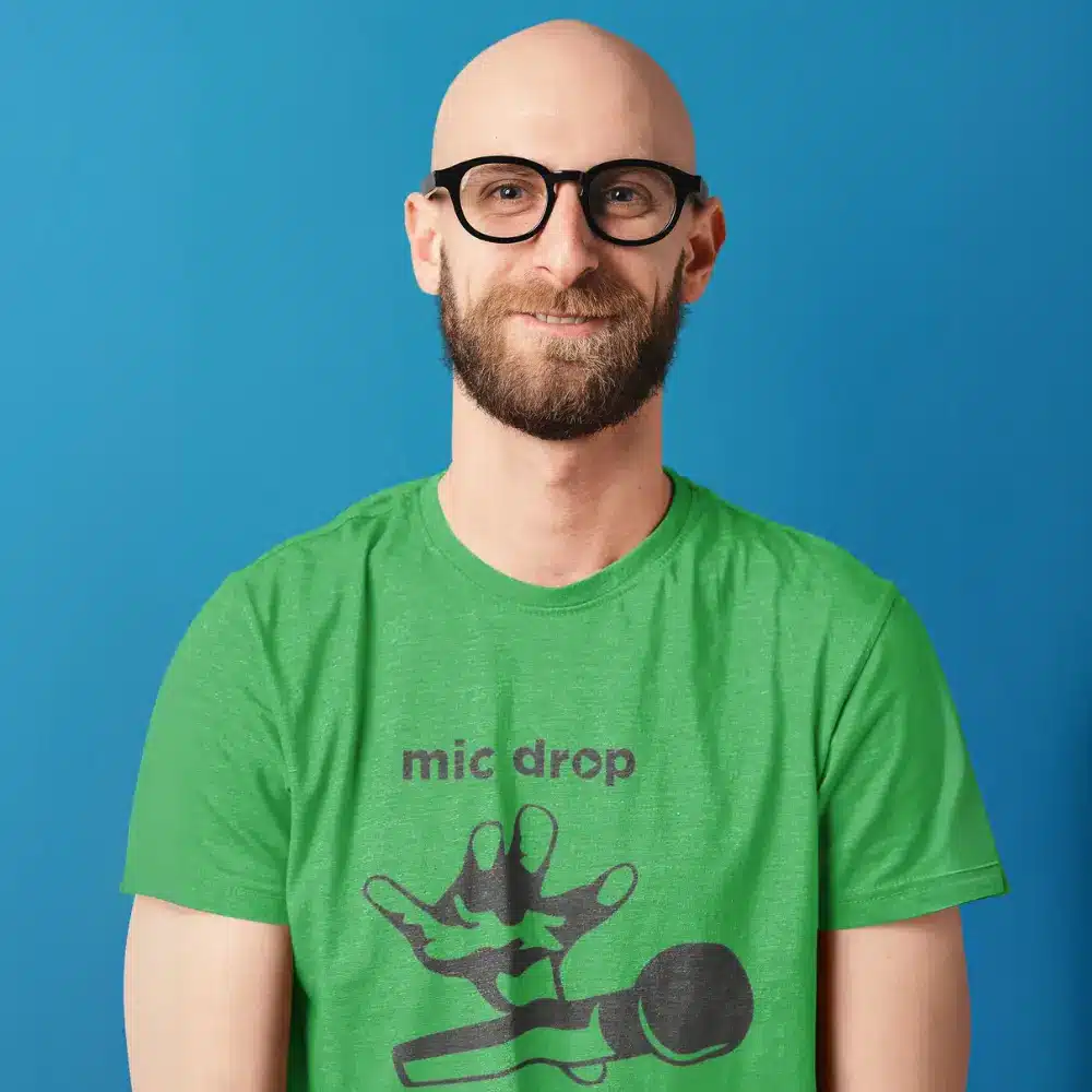 Man wearing a green t-shirt with a 'mic drop' design from the OTL Spotlight curated collection