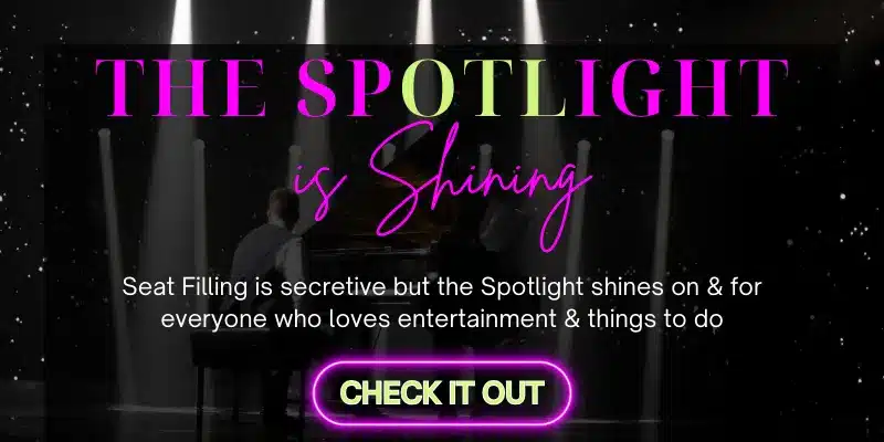 A promotional graphic with a dark background featuring spotlights shining down on a stage. The text in bold, colorful letters reads "The Spotlight is Shining." Below this, in smaller text, it says, "Seat Filling is secretive but the Spotlight shines on & for everyone who loves entertainment & things to do." At the bottom, there's a glowing neon button with the text "Check It Out.