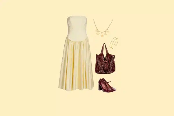 Women’s Hamilton theatre outfit with cream dress, burgundy heels, handbag, and gold jewelry.