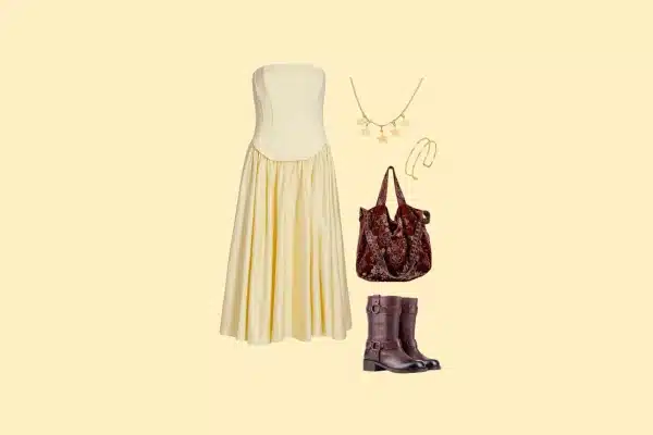 Cream strapless dress outfit with star necklace, velvet bag, and brown boots.