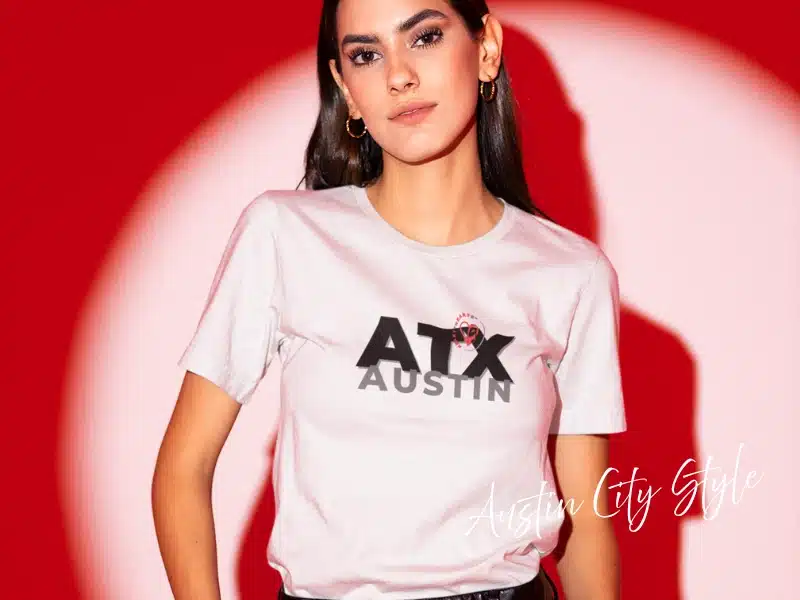 Model wearing “ATX Austin” City Style tee on a red background—Austin gifts & local merch idea.