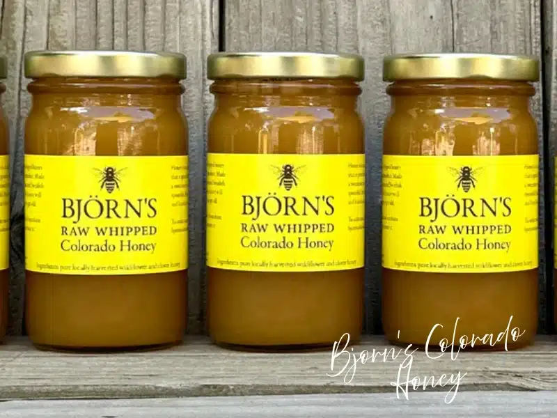 Björn’s Raw Whipped Colorado Honey jars on a wood shelf—Denver-made food gift idea.