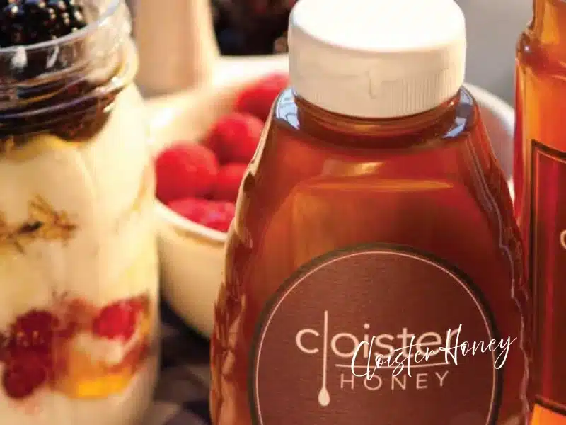 Cloister Honey bottle with yogurt parfait and berries—local Charlotte honey gift idea.