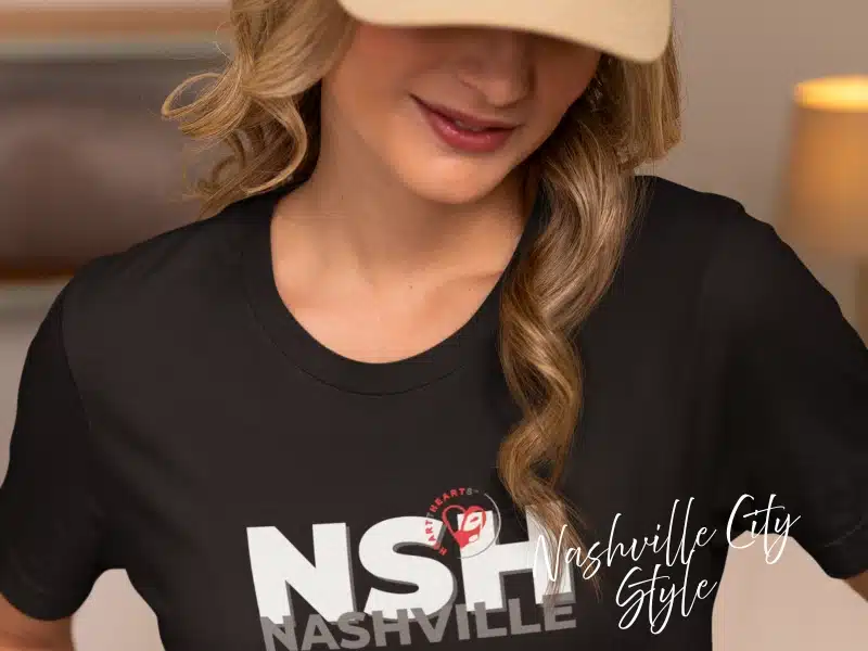 Woman wearing a black “NSH Nashville” City Style t-shirt—local pride apparel gift idea for Nashville.