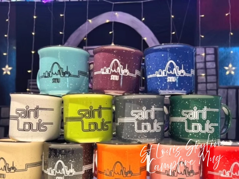 Stack of colorful campfire mugs with St. Louis skyline and Gateway Arch designs, STL-Style shop