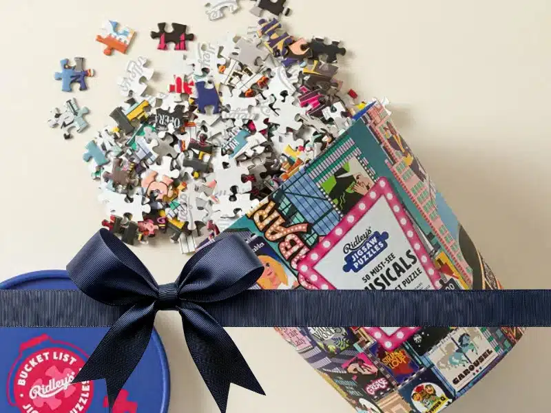 Musicals bucket-list jigsaw spilling pieces — fun gift for theatre lovers.