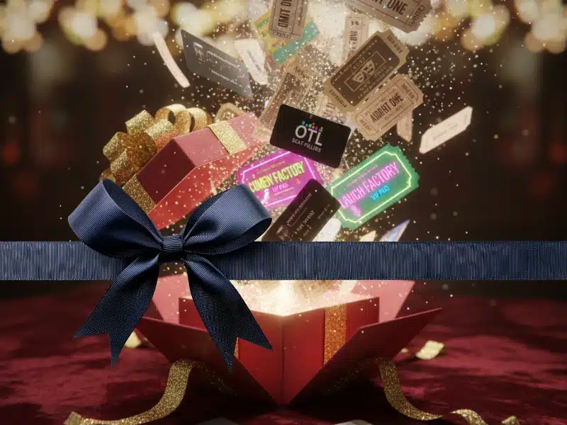 gift of experience: red gift box bursting with show tickets and VIP passes, wrapped with a navy bow