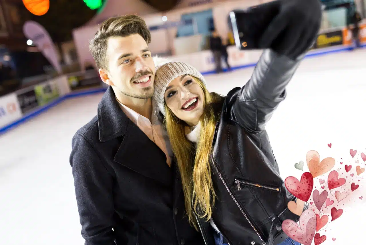 Budget-friendly things to do for Valentine’s Day: couple taking a selfie while ice skating, with watercolor heart accents.