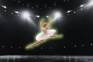 Jumping ballerina in a white tutu performing on stage for the Ultimate Guide to Ballet blog post on OTL Seat Fillers.