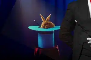Magician performing a classic rabbit-in-the-hat magic trick on stage