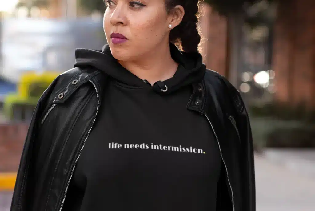 Life Needs Intermission dark hoodie with white text on the front.