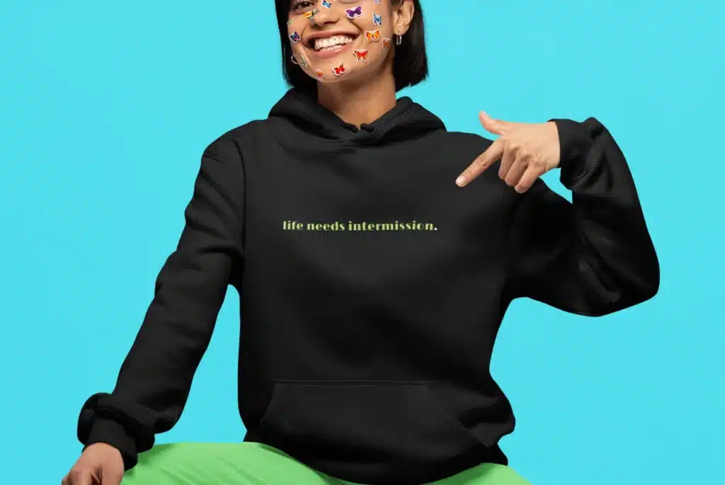 Life Needs Intermission dark hoodie with green text on the front.