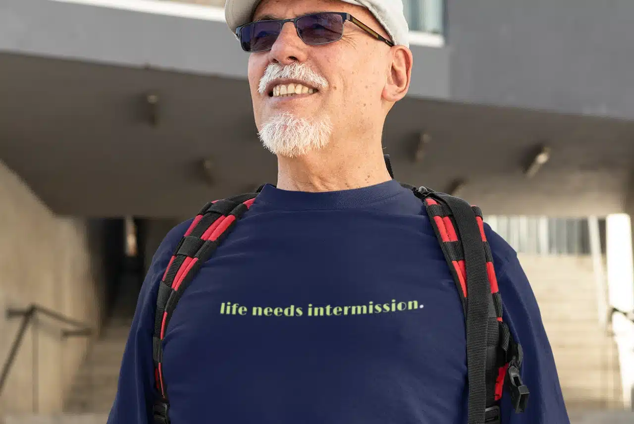 Life Needs Intermission dark long sleeve t-shirt with green text on the front.