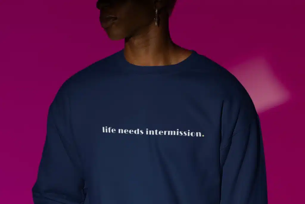 Life Needs Intermission dark crewneck sweatshirt with white text on the front.