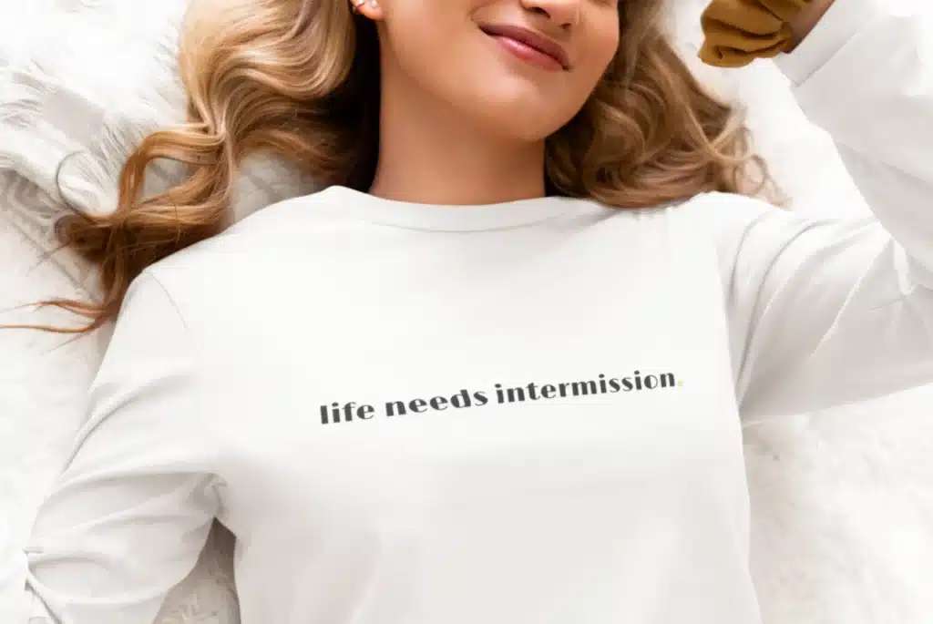 Life Needs Intermission light long sleeve t-shirt with black text on the front.