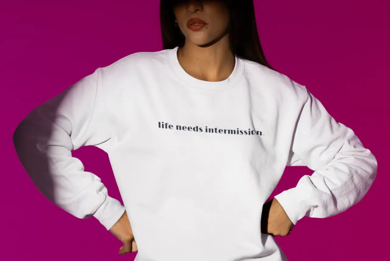 Life Needs Intermission light crewneck sweatshirt with black text on the front.