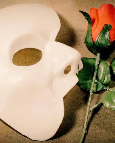 A mask and rose reminiscent of Phantom of the Opera representing the new Masquerade immersive show in NYC.