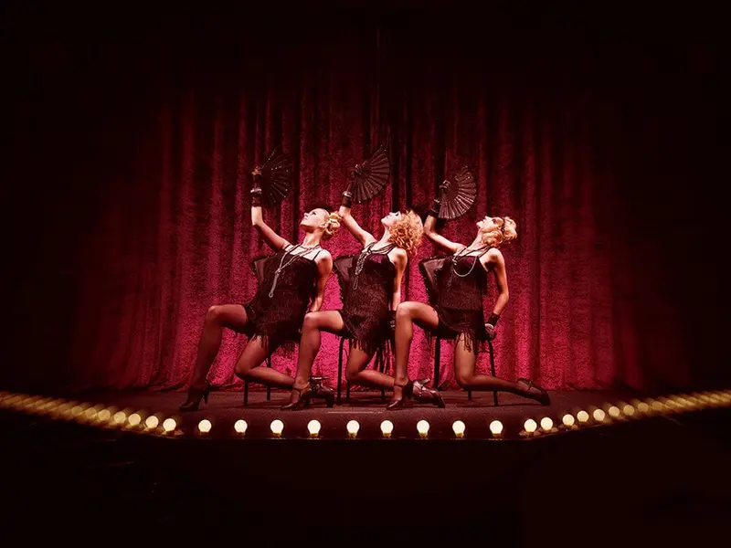 Red Velvet Burlesque Show performers on stage in vintage-inspired costumes with fans