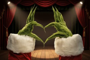 Green furry holiday hands form a heart above a theatre stage framed by red curtains and spotlights.