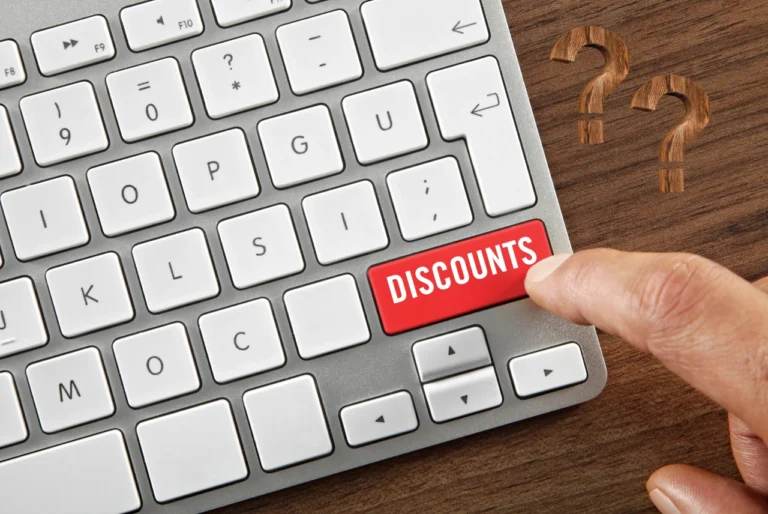 Finger pressing a red Discounts key on a computer keyboard for Fall 2026 ticket deals.